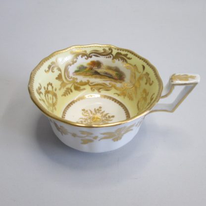 A Coalport porcelain rare yellow ground cup and saucer with three hand decorated English landscapes within shaped cartouches. Circa 1825 - Image 7
