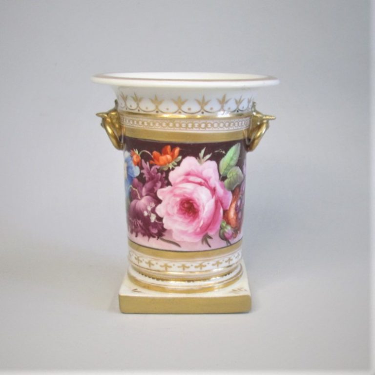 A spill vase with ring handles held in the beaks of gargoyles hand