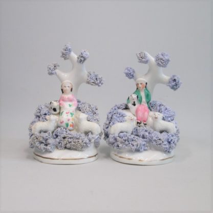 A small pair of Dudson figures modelled as seated Shepherd and Shepherdess  each with a dog and 2 sheep. Circa; 1830