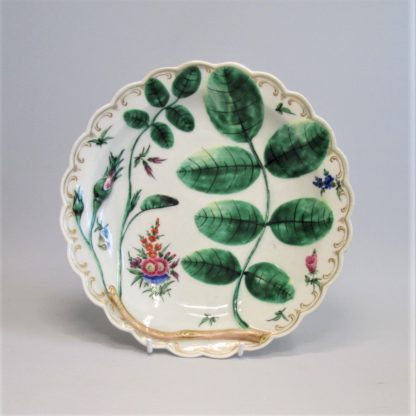 An eighteenth century Worcester porcelain Blind Earl dish, with raised moulding rose buds and leaves and a scalloped edge rim finished with a continuous gilt line. Circa: 1770.