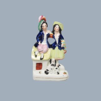 A Staffordshire pottery figure of young boy and girl with a dog and a puppy. Circa 1860