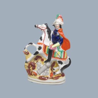 A Victorian Staffordshire military equestrian figure of a soldier with a sword and a canon and canon balls at his feet. Circa 1860.