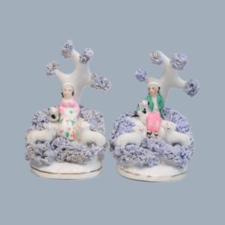 A small pair of Dudson figures modelled as seated Shepherd and Shepherdess  each with a dog and 2 sheep. Circa; 1830