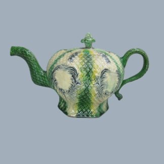 A Staffordshire Whieldon hexagonal teapot and cover with moulded decoration painted in green and vacant cartouches. Date Circa 1756
