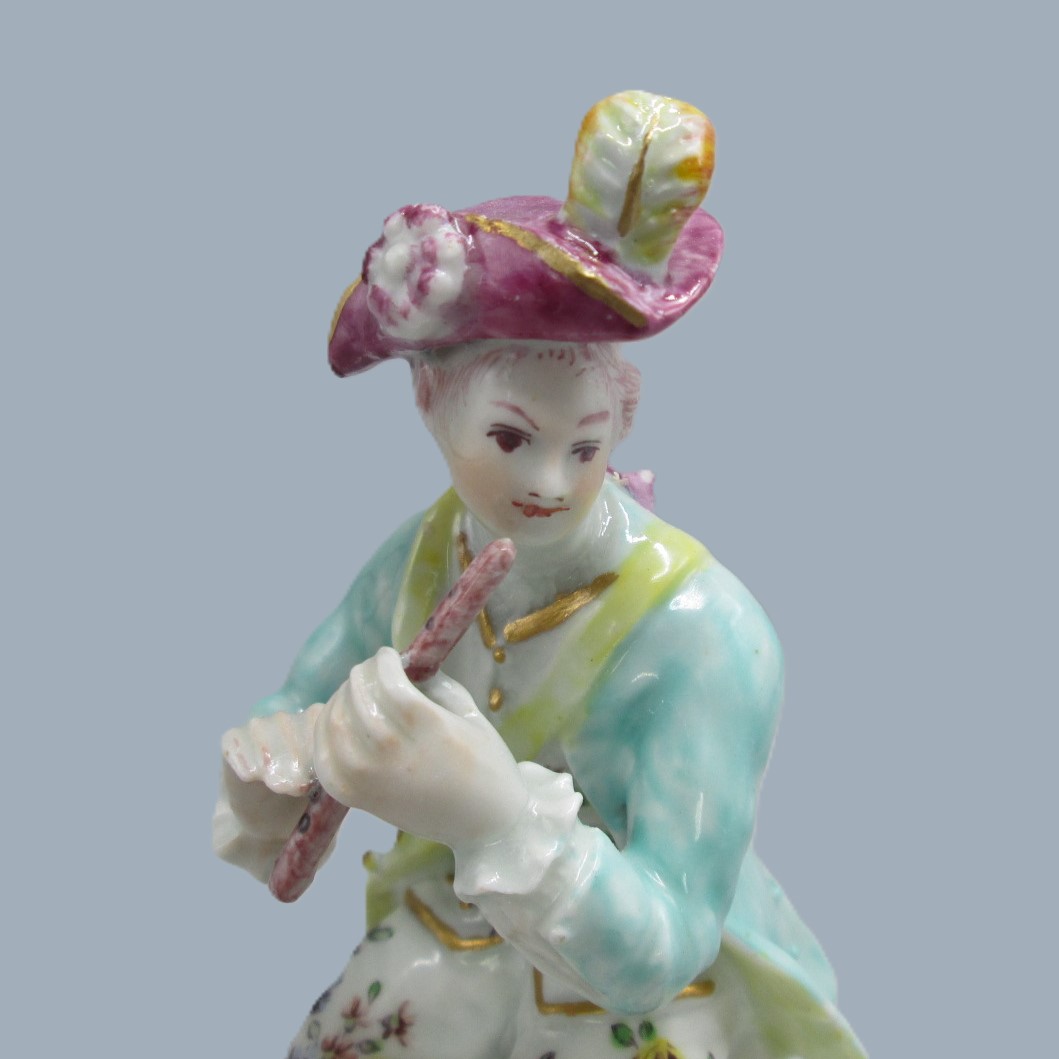 A Derby seated musician playing a flute hand decorated with a turquoise jacket and floral waistcoat and trousers. Circa 1756 - Image 2