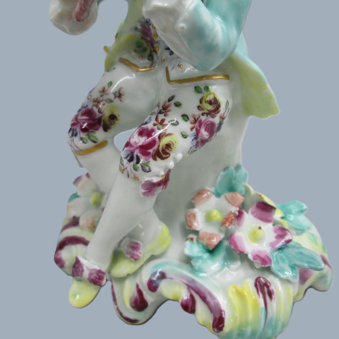 A Derby seated musician playing a flute hand decorated with a turquoise jacket and floral waistcoat and trousers. Circa 1756 - Image 9