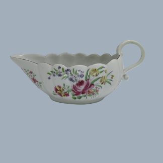 A Rare Derby poly-chrome fluted sauce boat with a scroll handle, hand decorated with finely painted colourful flowers. Circa 1760